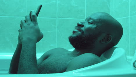 African-American-Man-Using-Phone-while-Taking-Bath